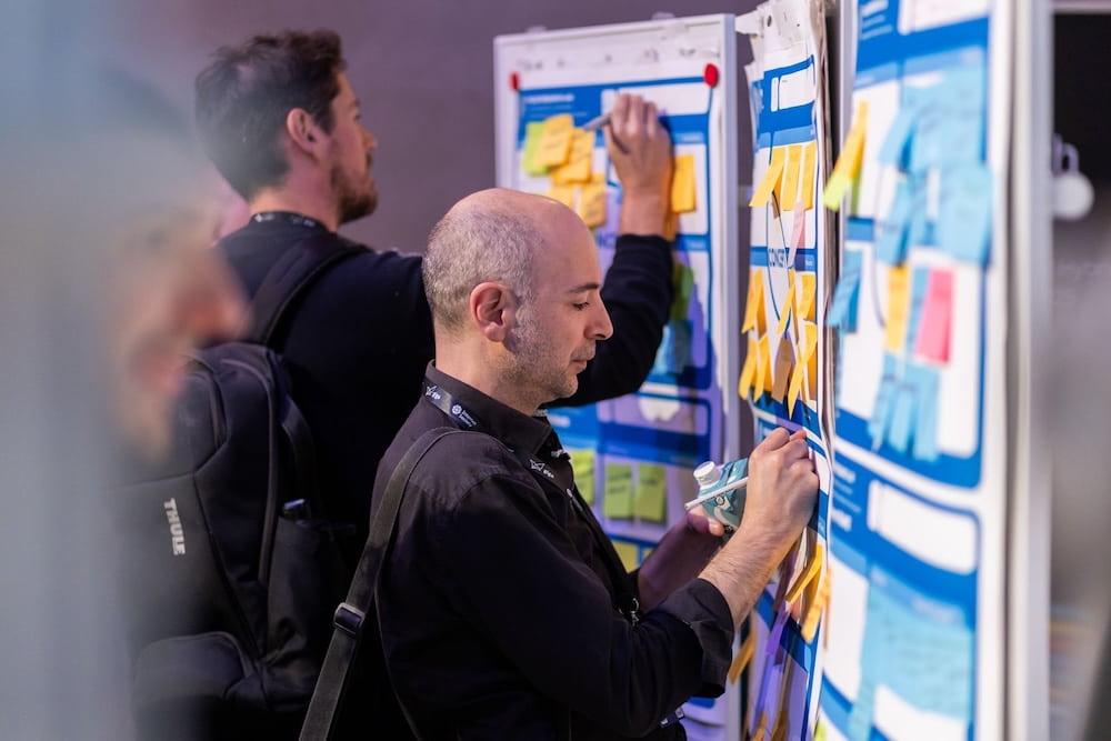 A man studies a poster board filled with various sticky notes