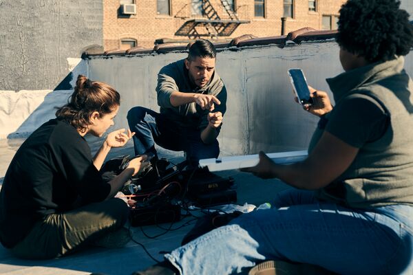 A trio of people sitting on the ground talking