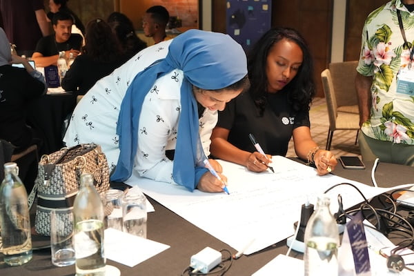 Women engaged in writing on paper.