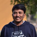 A man in a navy hoodie smiling