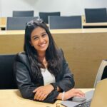 A woman, Ankita Rathi, sitting at the table and smiling