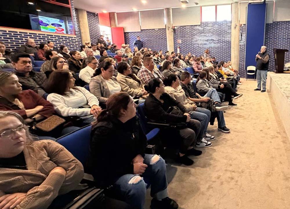 A man stands and speaks to a seated audience at a Mexico Chapter cybersecurity training. 