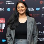 A woman, Nakshathra Suresh, standing in front of a panel.