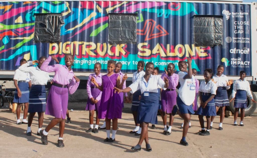 a group of girls dancing in front of a colorful truck