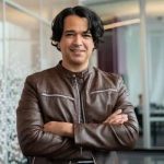 A man in brown leather jacket with arms crossed