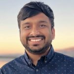 A man in a dark blue shirt smiling