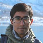 A man with glasses in a green jacket