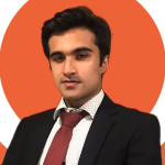 A man in a black suit with white shirt wearing red tie