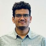 A man with glasses in a green plaid shirt