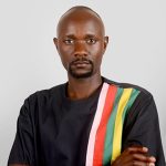 A man in black T-shirt with colourful stripes on the left side.