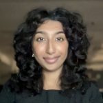 A woman with a black curly hair in a black shirt
