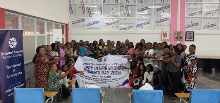 A large group of women hold up a Women's Day sign at a Nigeria Chapter event