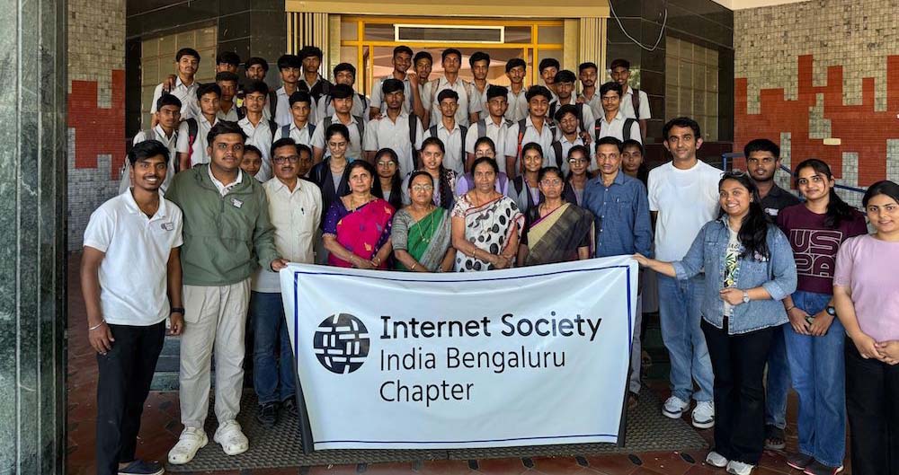 A large group of people stand and hold an Internet Society Bengaluru Chapter banner