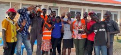 Des personnes se tiennent debout à l’extérieur pour célébrer l’achèvement du hub Internet dans la zone de Siripi, en faisant joyeusement signe à la caméra.