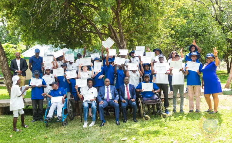 A group of people outdoors holding certificates.