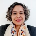 A woman with curly hair wearing a colorful floral scarf