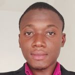 A young man wearing a suit and a pink shirt