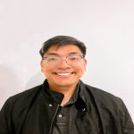 A man in black jacket smiling