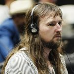 A man with long hair wearing headphones