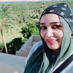 A woman with a headscarf smiles warmly