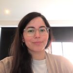 A woman wearing glasses and a white shirt