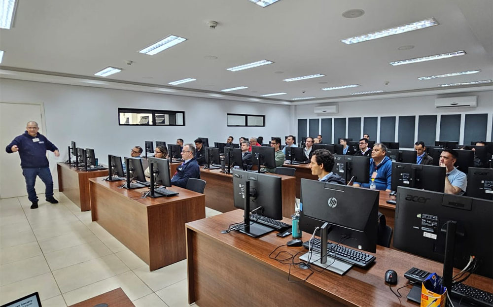 A man stands and talks to a group of people seated in a computer lab.