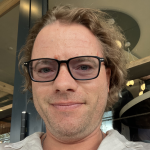 A man wearing glasses and a white shirt