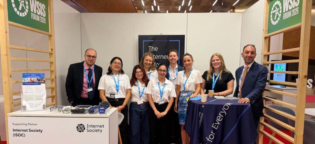 A group of people stand at an Internet Society event booth.