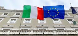 The Italy and EU flags wave side by side.