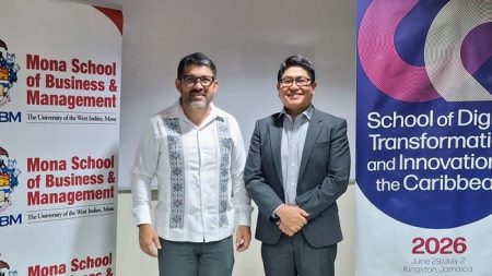 Two men stand beside a banner reading "School of Digital Transformation and Innovation."