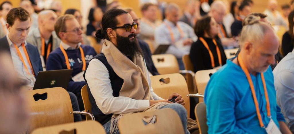 Amged B. Shwehdy sits in a seat, along with other audience members.