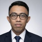 A man in a black suit and tie.