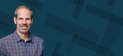 A headshot of Brian Haberman over a blue node background.