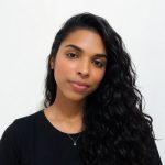 A woman with long curly hair in a black top.