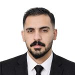 A man with a beard and mustache wearing a formal suit.