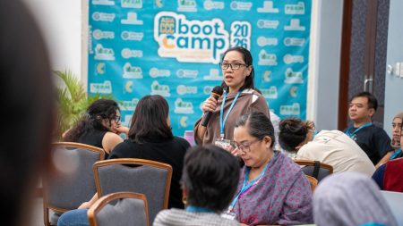A woman addressing a large crowd at a conference