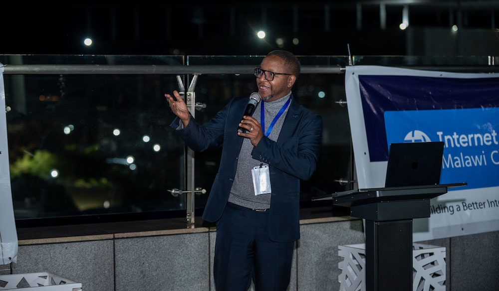 The president of the Internet Society Malawi Chapter stands and speaks into a microphone.
