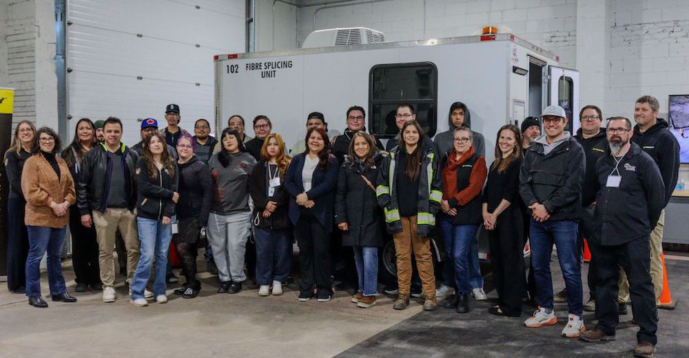 A large group of people poses for a photo indoors.