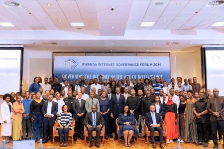 A large group of peopel gather together in front of a Rwanda Internet Governance Forum sign.