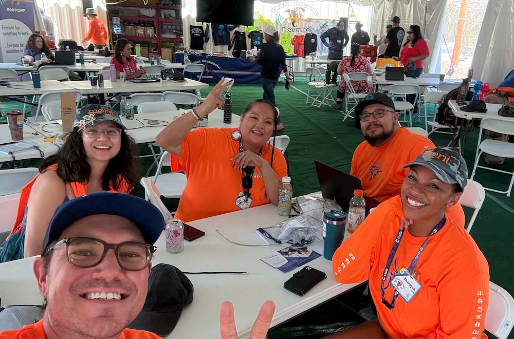 A selfie of five people sitting together at a table.