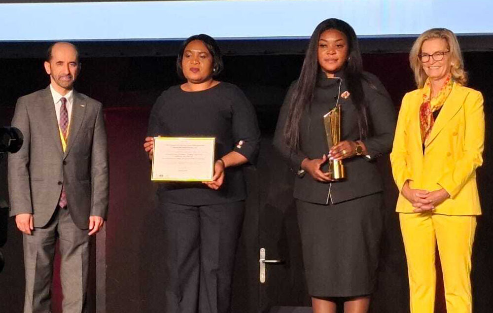 Four people stand up on a stage as representatives from the Internet Society Zimbabwe Chapter accept a WSIS Prize.